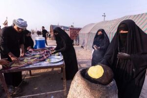 نساء عراقيات يقدمن للزوار خبز تنور الطين في المواكب الحسينية